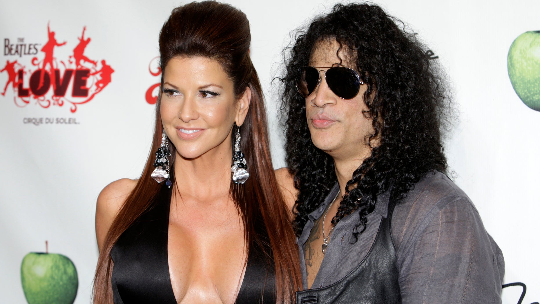 Perla Hudson (L) and Slash arrive for the fifth anniversary celebration of "The Beatles LOVE by Cirque du Soleil" show at the Mirage Hotel and Casino in Las Vegas, Nevada June 8, 2011. REUTERS/Steve Marcus (UNITED STATES - Tags: ENTERTAINMENT) - RTR2NGWG
