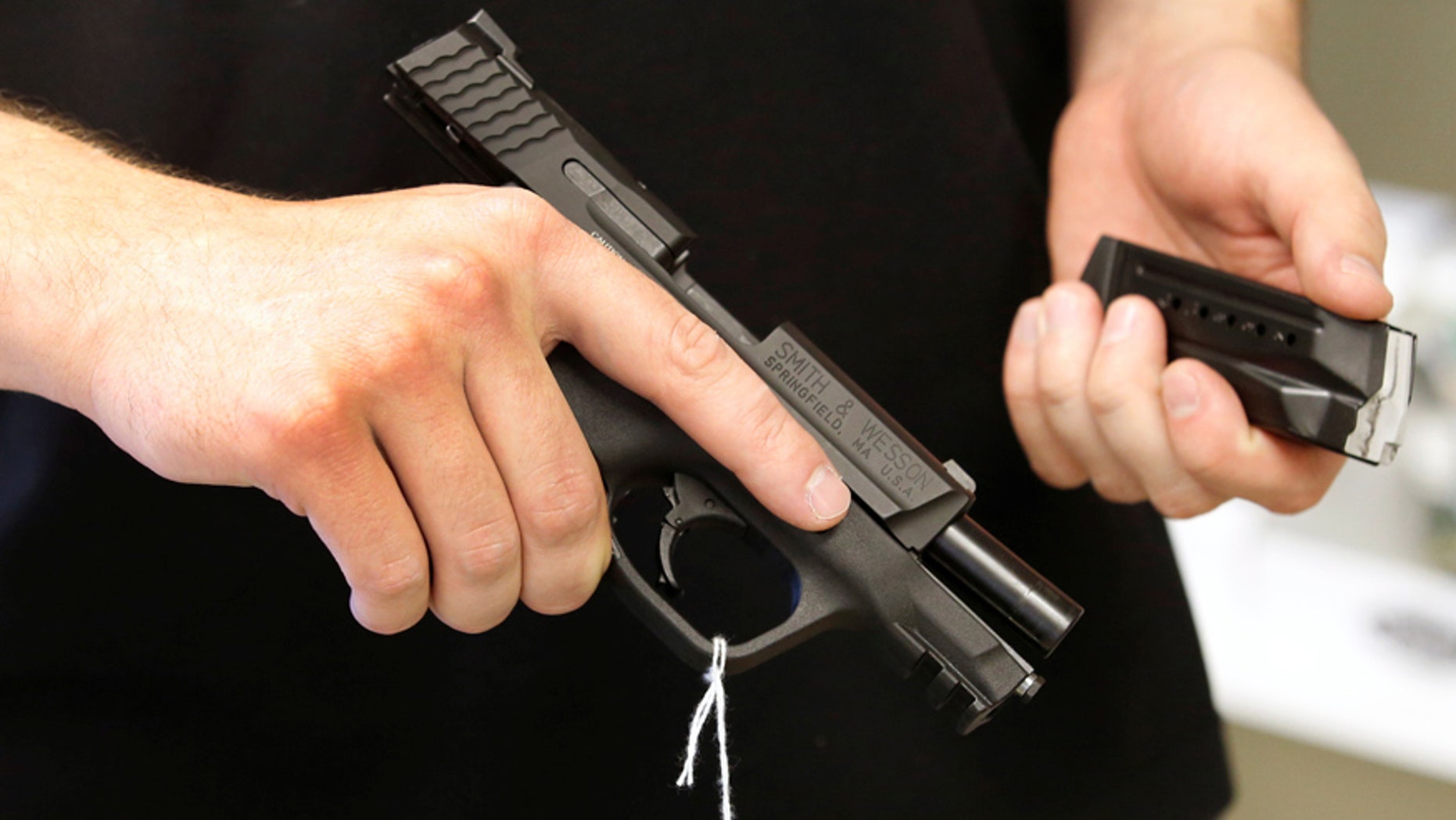 June 21, 2016: Salesman Ryan Martinez hold an Smith & Wesson handgun and magazine at the "Ready Gunner" gun store in Provo, Utah.