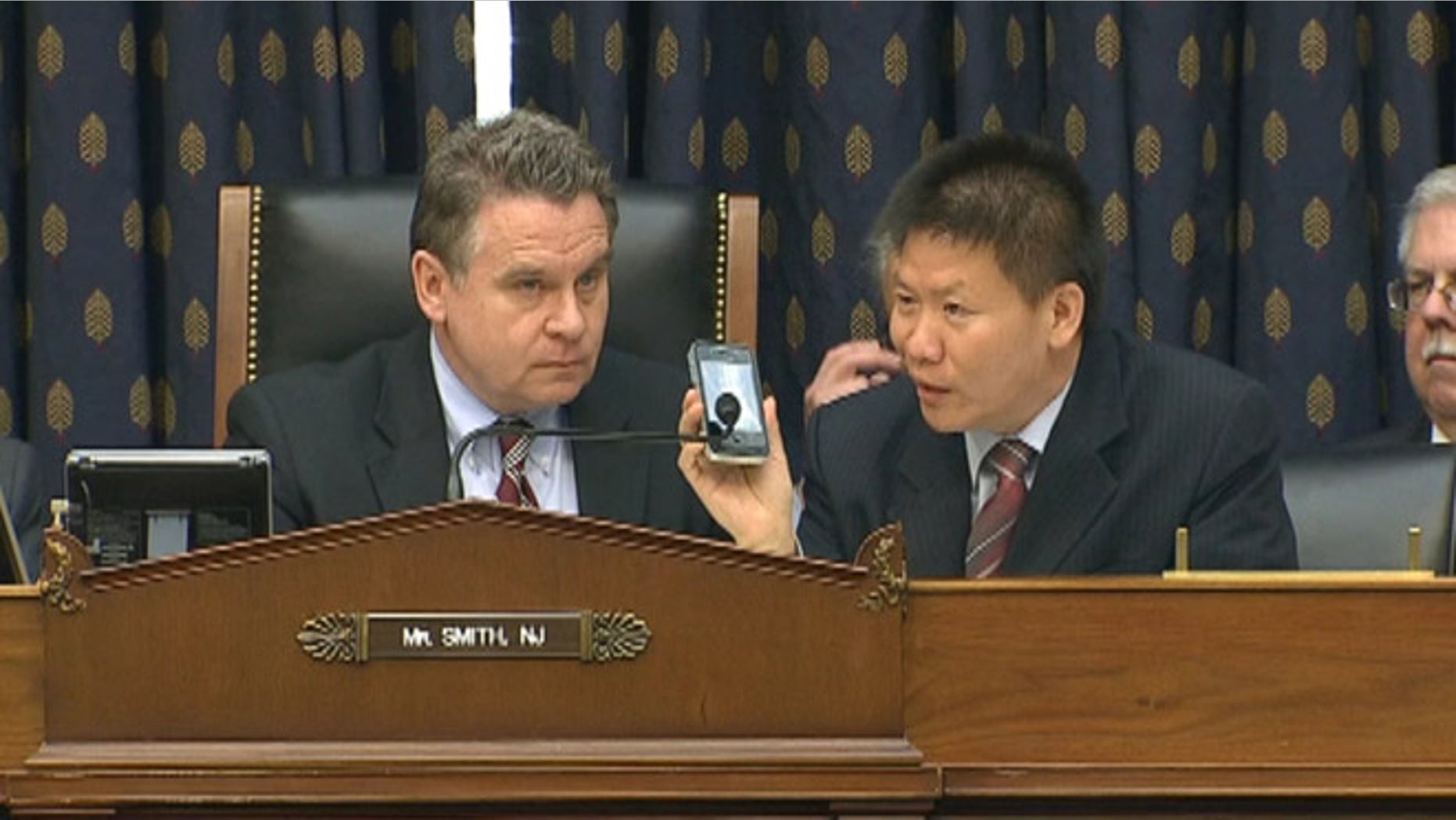 May 3, 2012: Rep. Chris Smith, left, and ChinaAid President Bob Fu, right, listen as Chinese activist Chen Guangcheng addresses a Capitol Hill committee over the phone.