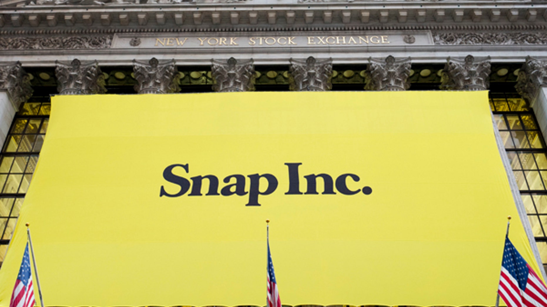 A banner for Snap Inc. hangs from the front of the New York Stock Exchange, Thursday, March 2, 2017, in New York. The company behind the popular messaging app Snapchat is expected to start trading Thursday after a better-than-expected stock offering. (AP Photo/Mark Lennihan)