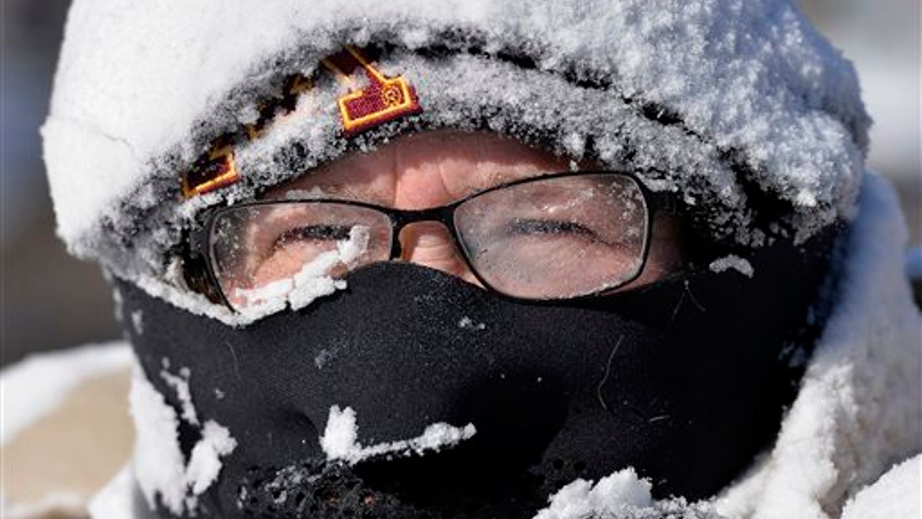 Milissa Preiss peers out from behind snow-covered glasses while clearing her Sartell, Minn., driveway Tuesday, March 3, 2015. A fast-moving storm dumped several inches of snow across the Upper Midwest on Tuesday, making travel treacherous in some areas and leading to at least several traffic-related fatalities. (AP Photo/The St. Cloud Times, Kimm Anderson)