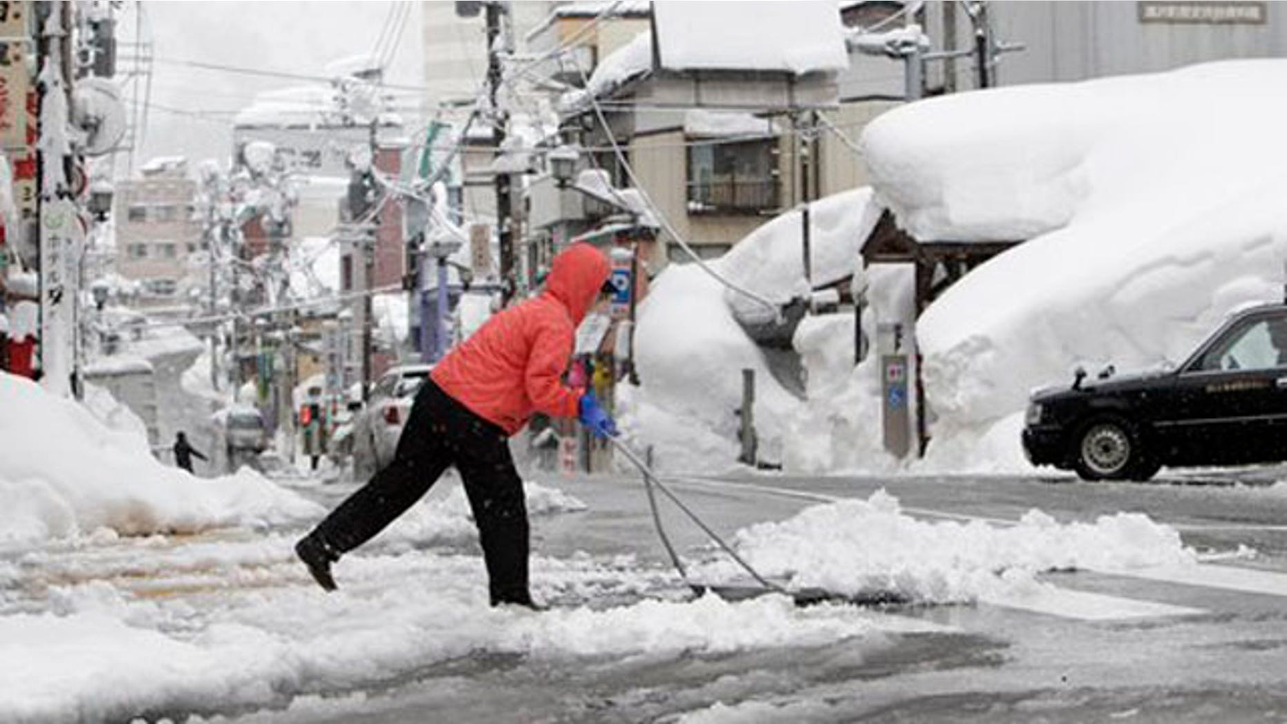 Feb. 1, 2012: A woman removes snow off a street in Yuzawa, Niigata prefecture, north of Tokyo.