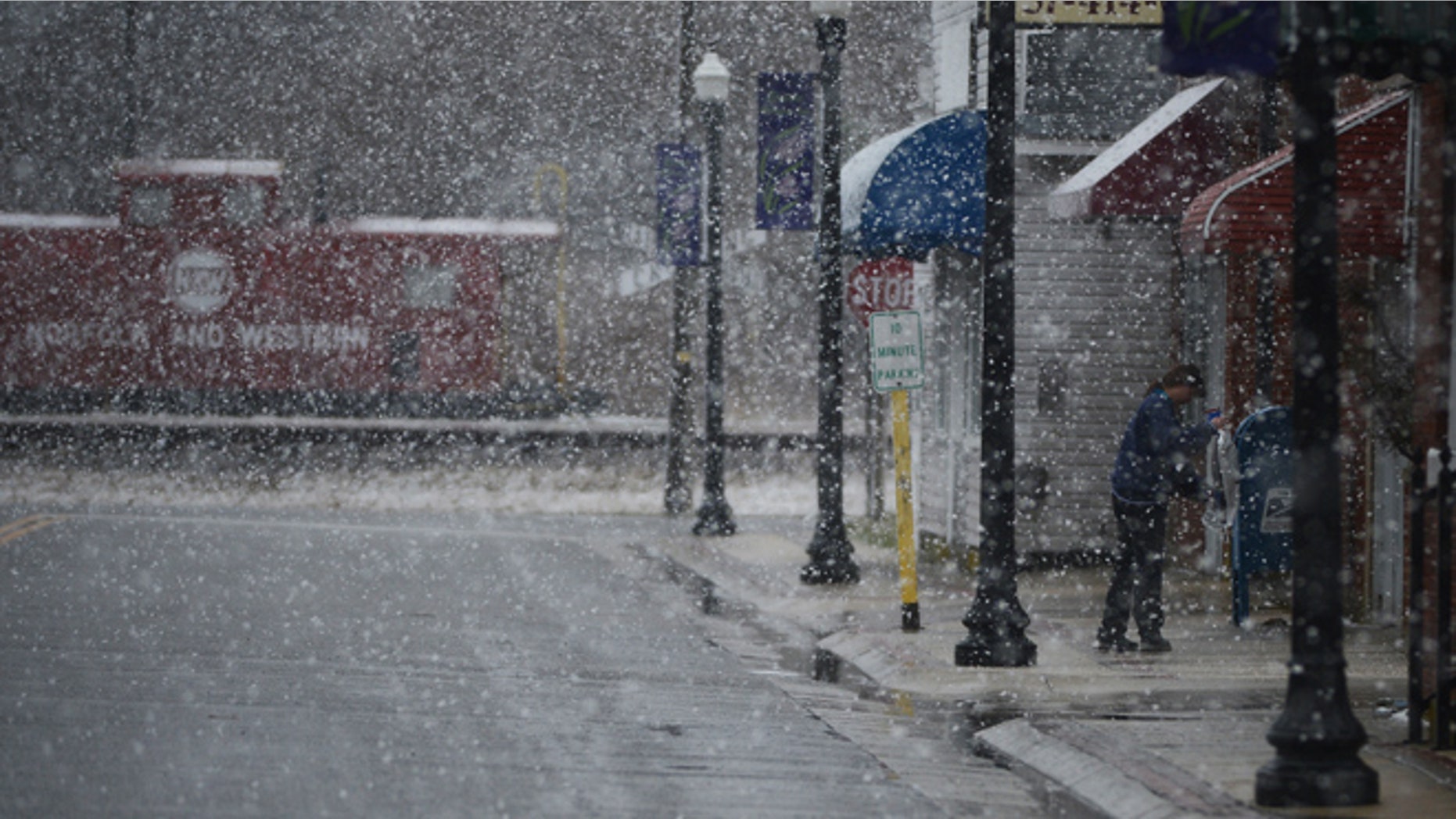 March 25, 2014: U.S. Postal employee Janeen Long salts and sands the sidewalk in front of the Exmore, Va. Post Office during a heavy snow fall.