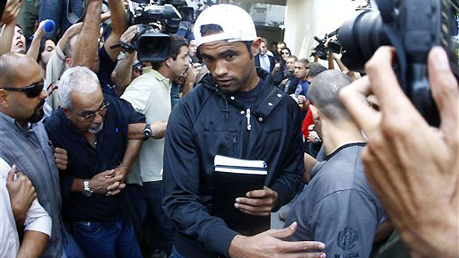 July 8: Flamengo's goalkeeper Bruno Souza walks from a police station to Gericino prison as he is surrounded by police and members of the press in Rio de Janeiro.