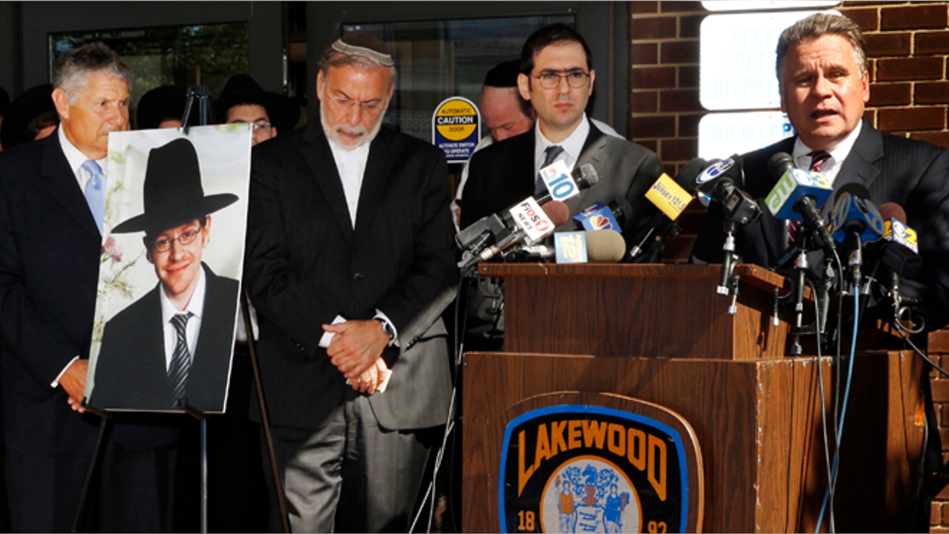 Aug. 26, 2014: U.S. Rep. Chris Smith, right, R-NJ, addresses a gathering as he stands near a photograph of Aaron Sofer, center, 23, in Lakewood, N.J. (AP/Mel Evans)