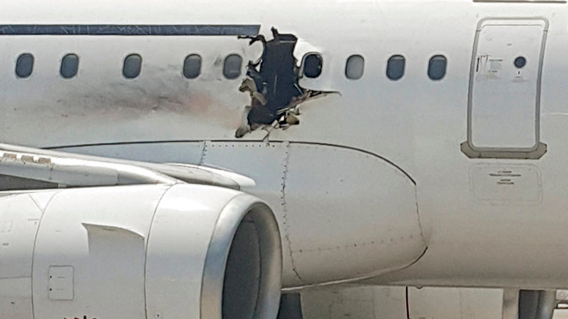FILE: A hole is photographed in a plane operated by Daallo Airlines as it sits on the runway of the airport in Mogadishu, Somalia. Abdullahi Abdisalam Borleh boarded the plane on Feb. 2 with a bomb which exploded at 11,000 feet.