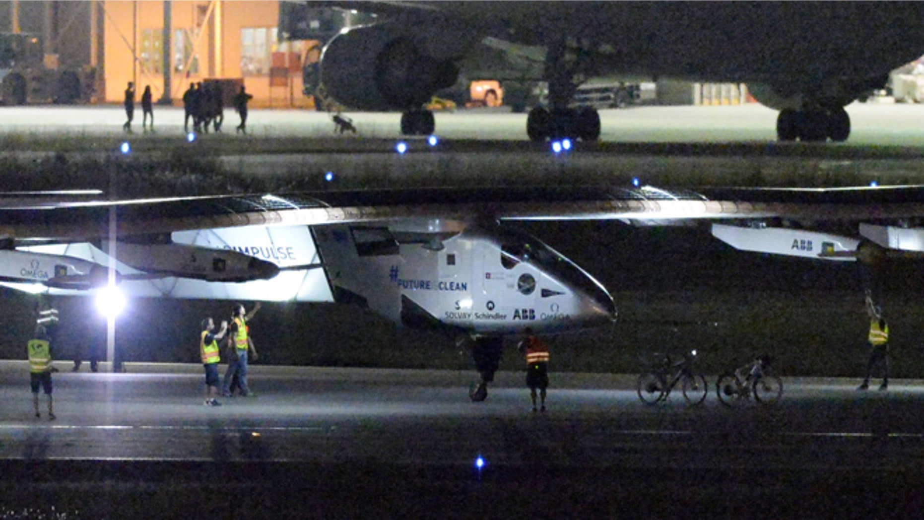 June 1, 2015: The Solar Impulse 2 project staff members gather around the aircraft as it lands the Nagoya Airport in Toyoyama, near Nagoya, central Japan.