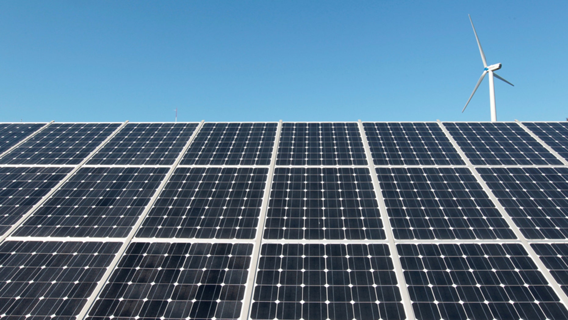 File photo - A wind turbine is seen over the panels of a solar power plant of Korea South East Power Co. (KOSEP) in Incheon, in this file photo taken September 30, 2010. (REUTERS/Jo Yong-Hak/File Photo)
