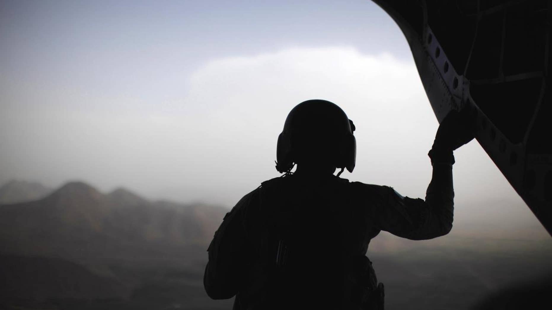 A U.S. Army crewman sits at the rear of a CH-47 Chinook helicopter over eastern Afghanistan, Monday, June 6, 2011. (AP Photo/Jason Reed, Pool)