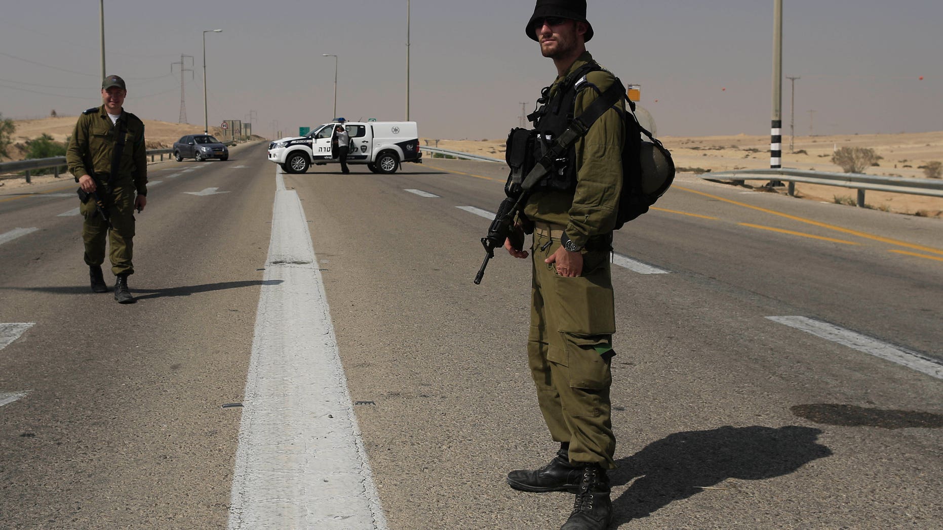 Israeli security forces secure the area after an attack, near the southern Israeli city of Beersheva, Monday, June 18, 2012. Unidentified militants crossed from Egypt's turbulent Sinai Peninsula into southern Israel on Monday, opening light arms and anti-tank fire on civilians building a security fence meant to fortify the porous border, defense officials said. One of the Israeli workers was killed, and two militants were gunned down by troops responding to the attack, the officials said. (AP Photo/Tsafrir Abayov)