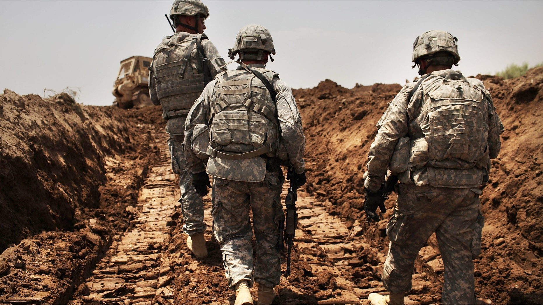 ISKANDARIYA, IRAQ - JULY 19: U.S. soldiers with the 3rd Armored Cavalry Regiment patrol a new ditch they have dug to protect the base from attack on July 19, 2011 in Iskandariya, Babil Province Iraq. As the deadline for the departure of the remaining American forces in Iraq approaches, Iraqi politicians have agreed to meet in two weeks time in order to give a final decision about extending the U.S. troops' presence beyond the end of the 2011 deadline. Violence against foreign troops has recently picked-up with June being the worst month in combat-related deaths for the military in Iraq in more than two years. Currently about 46,000 U.S. soldiers remain in Iraq. (Photo by Spencer Platt/Getty Images)