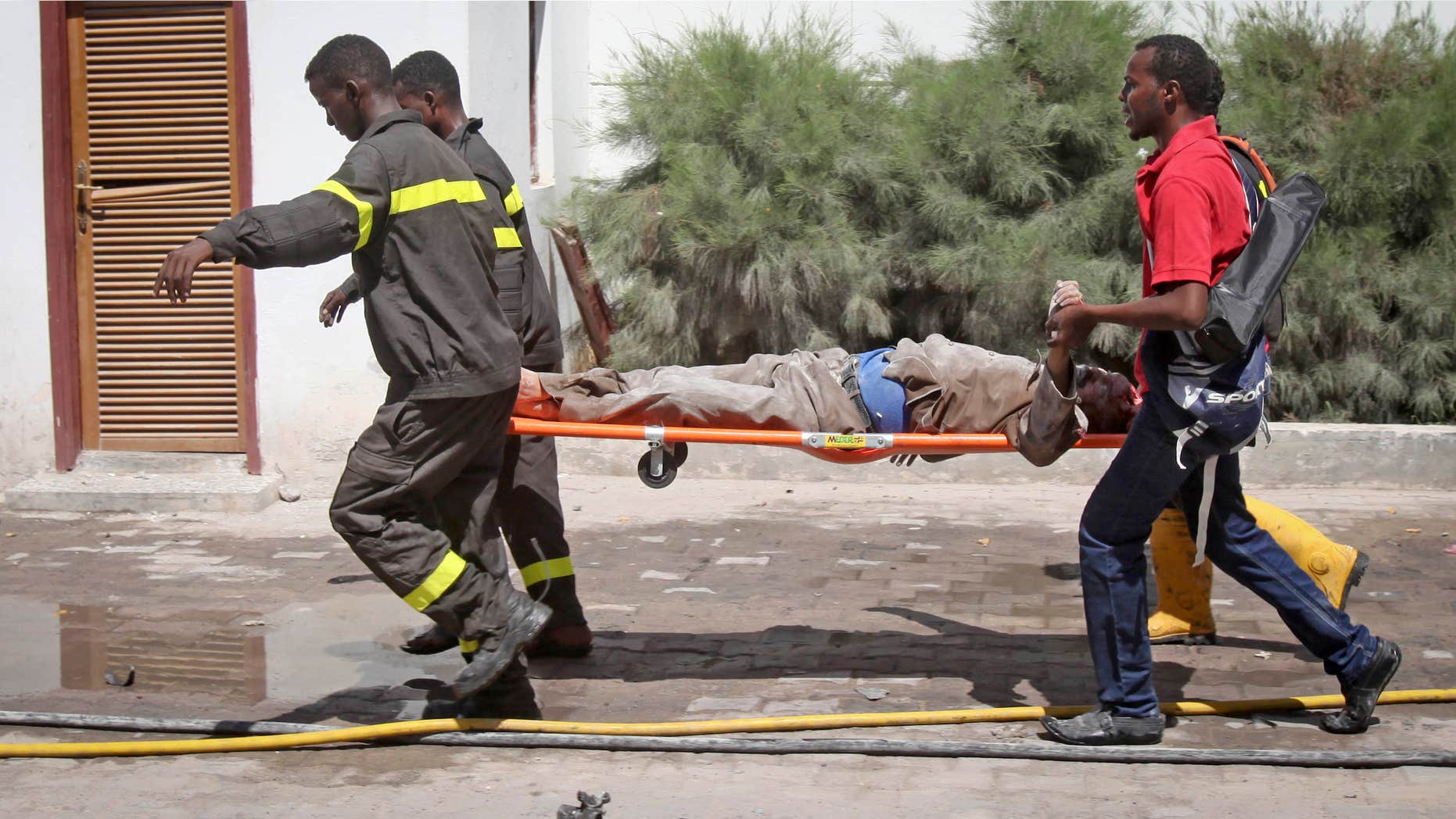 Feb. 20, 2015: Somali rescuers carry away a severely injured civilian from the scene of a twin bombing attack on a hotel in the capital Mogadishu, Somalia.
