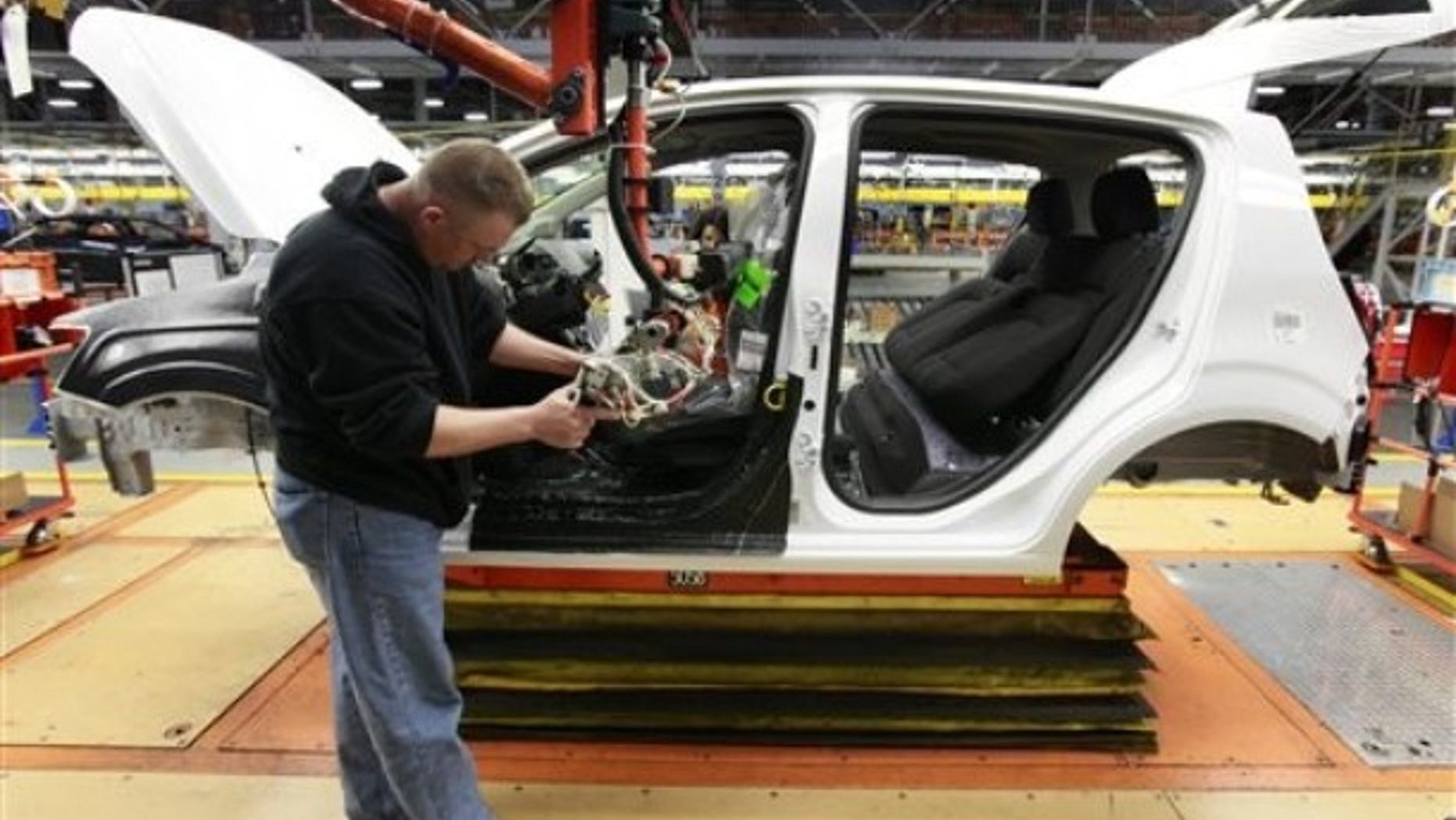 In this May 19, 2011 photo, line worker David Beebe works on a pre-production Chevrolet Sonic at the General Motors Orion Assembly plant in Orion Township, Mich. General Motors said Friday, June17, 2011, that pricing for its new Chevrolet Sonic will start at just under $15,000. The sub-compact car is set to hit dealer lots this fall. (AP Photo/Paul Sancya)