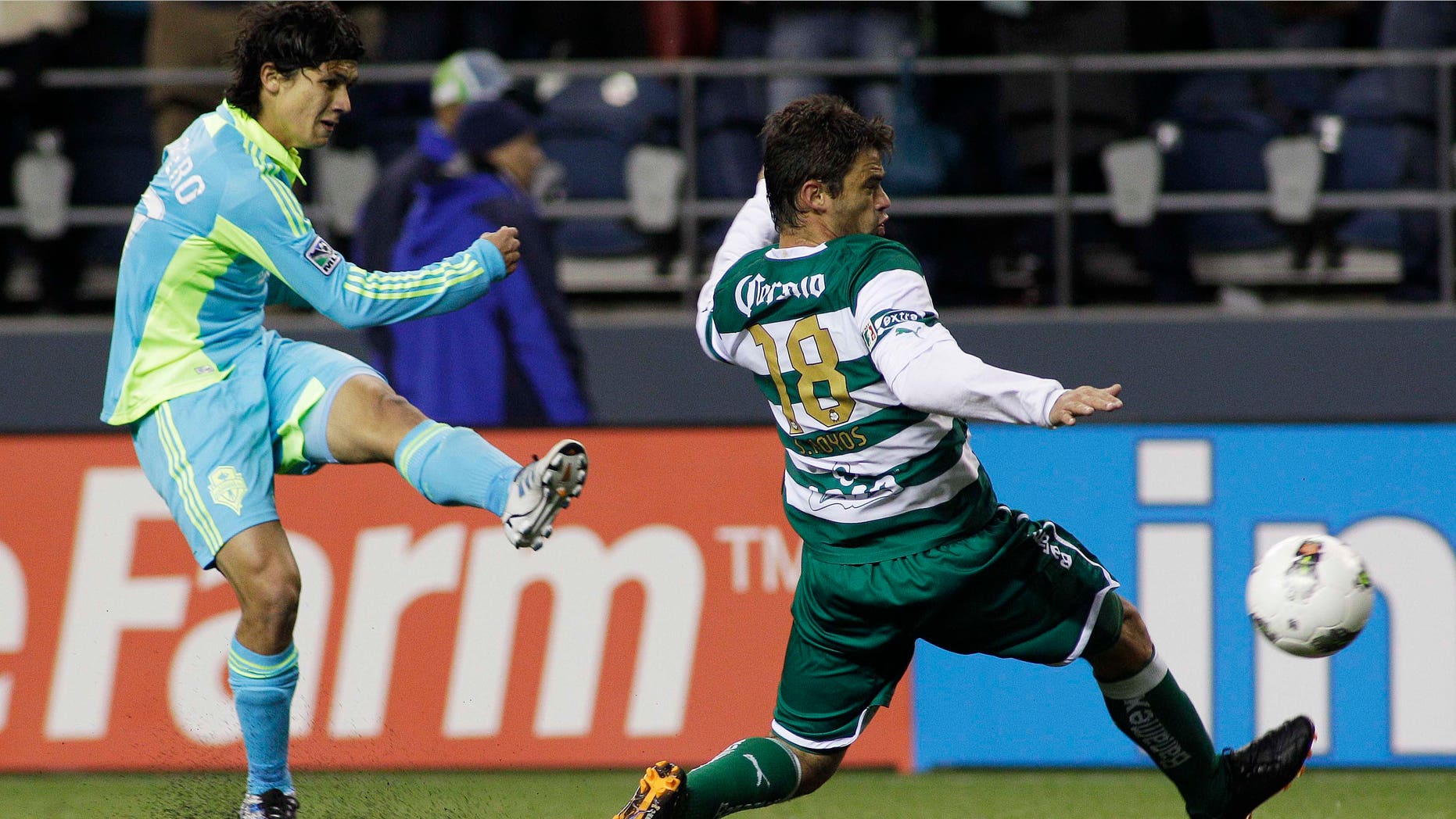 Seattle Sounders FC's Fredy Montero, left, shoots past Santos Laguna's Santiago Hoyos in the second half of a CONCACAF Champions League quarterfinal soccer match, Wednesday, March 7, 2012, in Seattle. The Sounders beat Santos, 2-1.