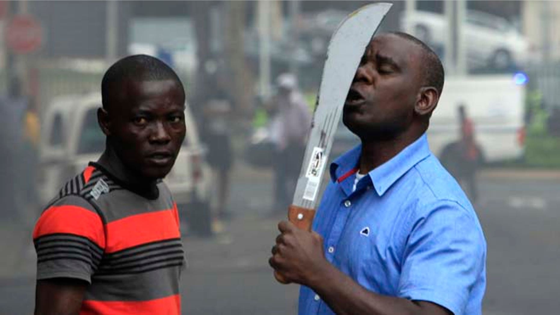 April 14, 2015: In this photo taken in Durban, South Africa, an immigrant armed with a machete on a street during clashes with police and in search of locals that attacked foreign shop owners in the city center.