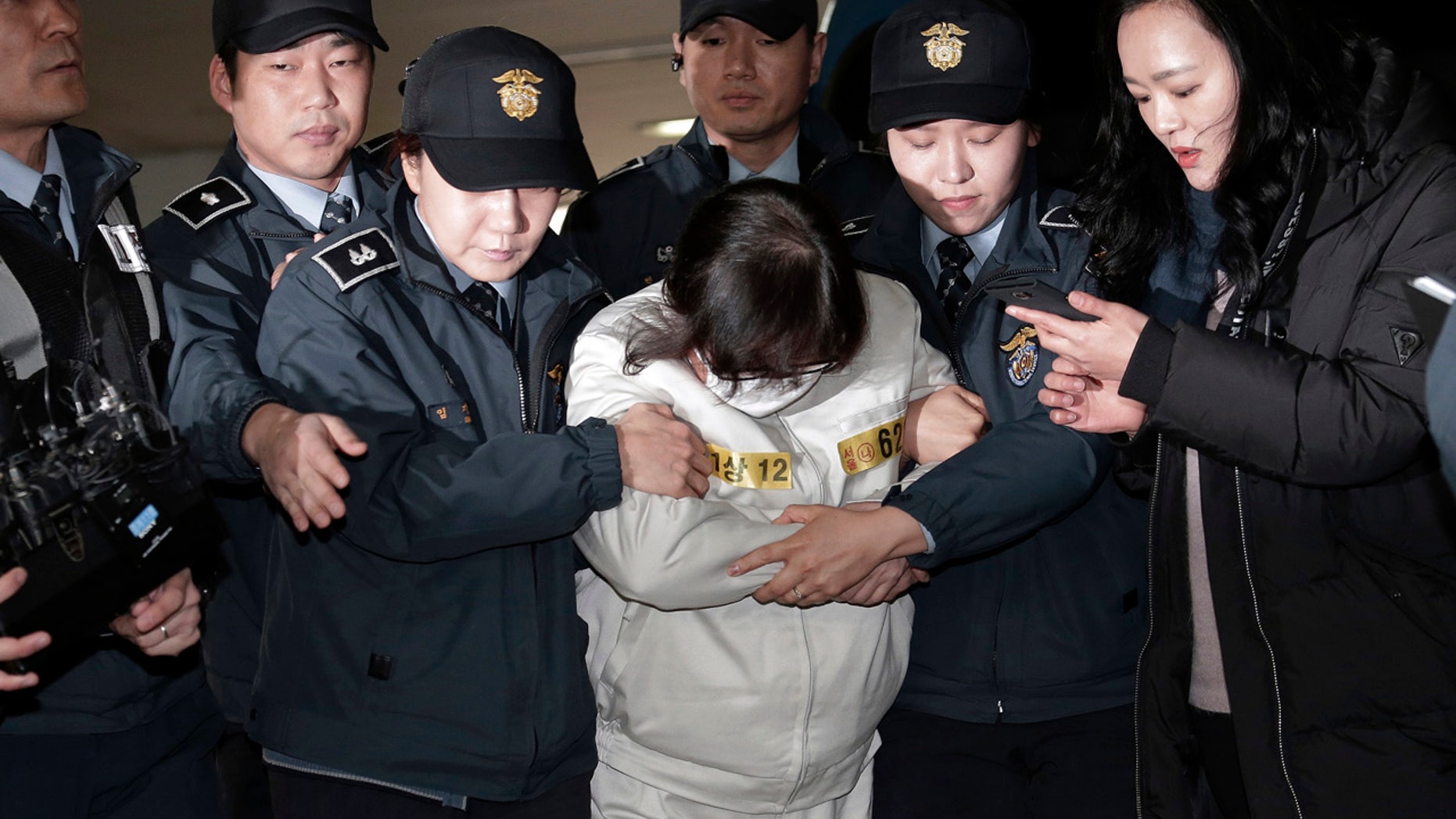 Choi Soon-sil, center, the jailed confidante of disgraced South Korean President Park Geun-hye, arrives for questioning into her suspected role in political scandal at the office of the independent counsel in Seoul, South Korea, Saturday, Dec. 24, 2016.