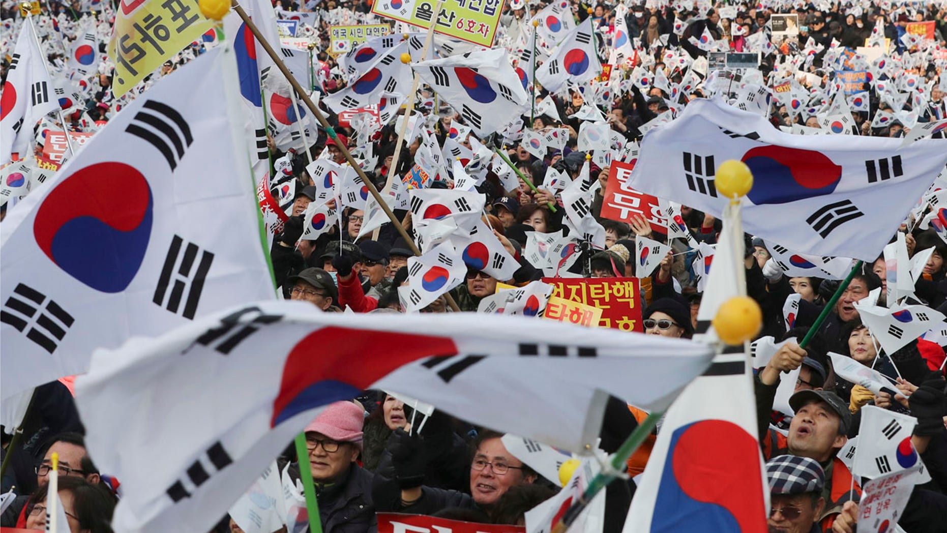 Supporters of South Korean President Park Geun-hye wave their national flags during a rally opposing her impeachment in Seoul, South Korea, Saturday, Dec. 31, 2016.