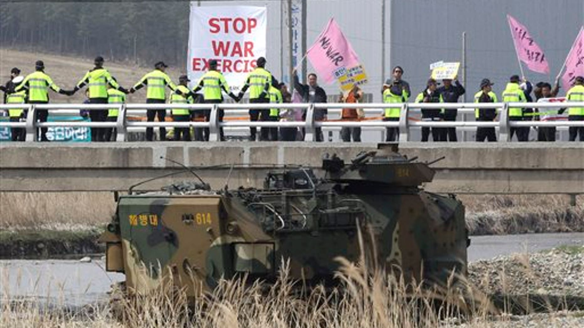 Anti-war protesters stage a rally during the U.S.-South Korea joint landing exercises called Ssangyong as part of the Foal Eagle military exercises in Pohang, South Korea, Monday, March 31, 2014. South Korea on Monday returned fire into North Korean waters after shells from a North Korean live-fire drill fell south of the rivals' disputed western sea boundary, a South Korean military official said. (AP Photo/Ahn Young-joon)