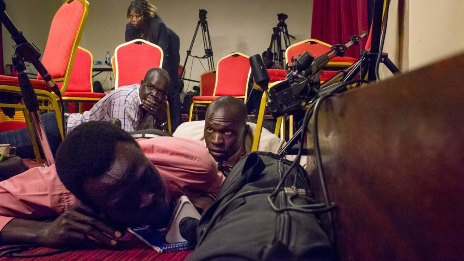Journalists lie on the floor of a press room in the South Sudan presidential palace after shots were heard on Friday.
