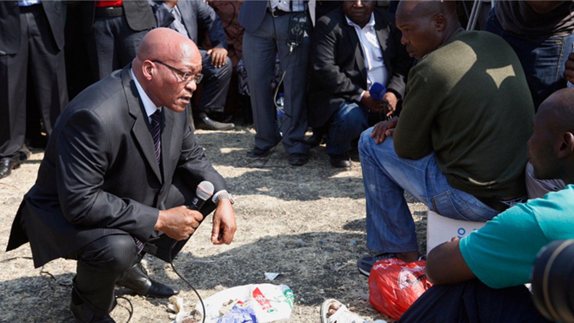 August 22, 2012: South Africa's President Jacob Zuma, left, interacts with striking mine workers at the Lonmin mine near Rustenburg, South Africa.