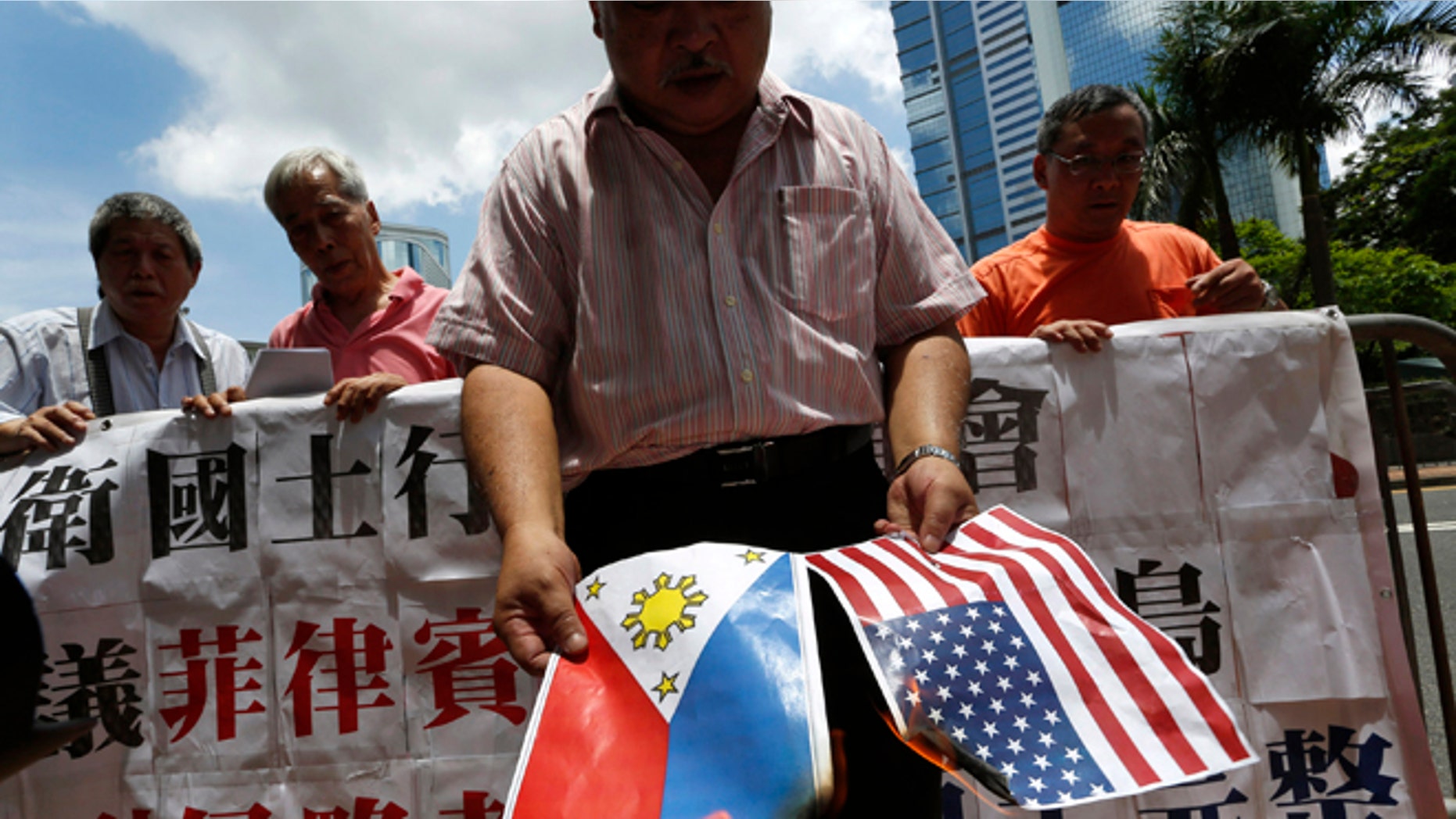 May 10, 2012: A protesters burns a Philippine flag and a U.S. flag during a protest outside the Philippines Consulate in Hong Kong.