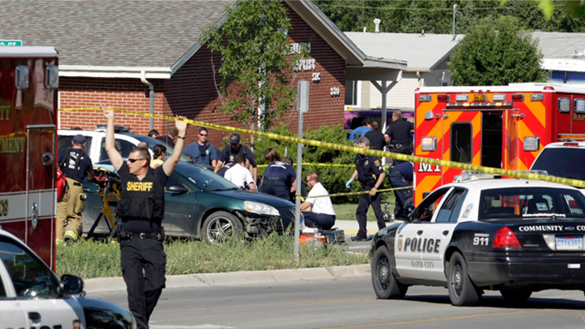 Aug. 2: Rapid City Firefighter/Paramedics and Rapid City Police Department personnel respond to shootings at the intersection of Anamosa and Greenbriar streets, in Rapid City, S.D. A Rapid City police officer was killed and two others were seriously wounded after a shootout with a man during a routine stop in the South Dakota city, authorities said late Tuesday. Gunfire erupted about 10 minutes after the three officers approached four people at an intersection.