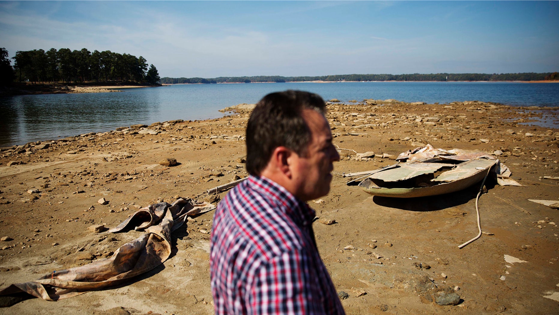 In this Wednesday, Oct. 26, 2016, file photo, a sunken boat is exposed by receding water levels on Lake Lanier as U.S. Army Corps of Engineers Natural Resources Manager Nick Baggett looks on in Flowery Branch, Ga.