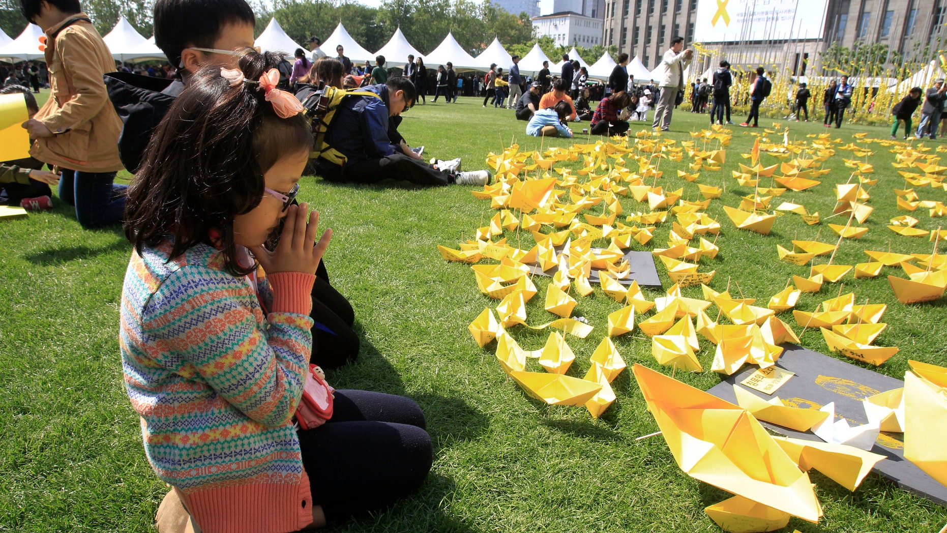 May 5, 2014: A girl prays in front of paper ships bearing messages for the victims of the sunken ferry Sewol at a group memorial altar in Seoul, South Korea.