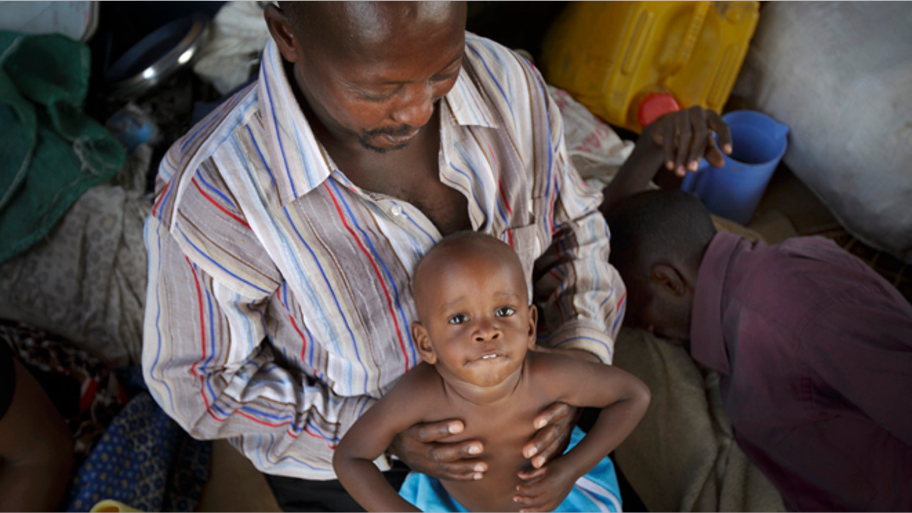 Dec. 30, 2013: A displaced Ugandan boy is held by a relative as they wait for an evacuation flight from the United Nations camp where they have sought shelter in Malakal, South Sudan. When violence broke out in Juba on Dec. 15 life remained calm but tense in Malakal, the capital of oil-producing Upper Nile state, but the violence then radiated outward from Juba and full-fledged war broke out in the town on Christmas Day, as army commanders defected and pledged allegiance to the country's ousted vice president, in most cases pitting the ethnic group of President Salva Kiir, a Dinka, against ethnic Nuers. (AP/Ben Curtis)