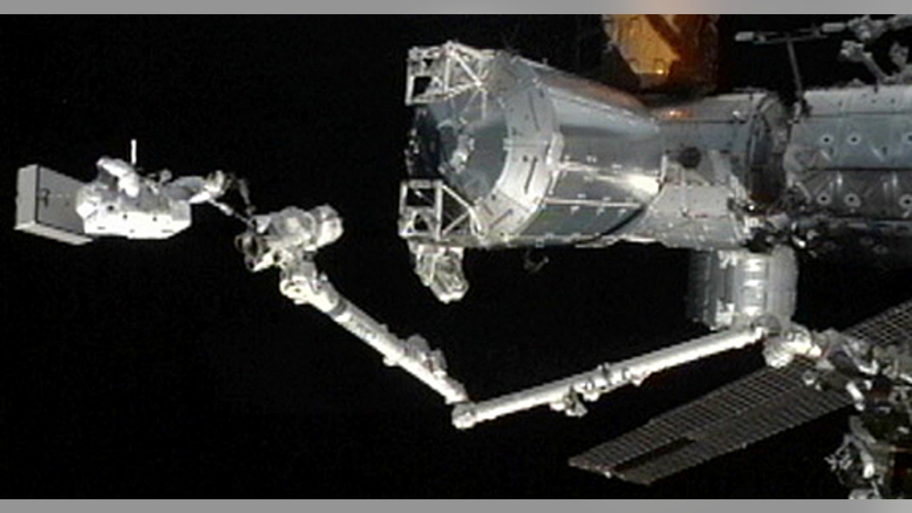 Japanese astronaut Akihiko Hoshides stands a the tip of the International Space Station's robotic arm during an Aug. 30, 2012, spacewalk outside the orbiting lab with crewmate Sunita Williams of NASA.