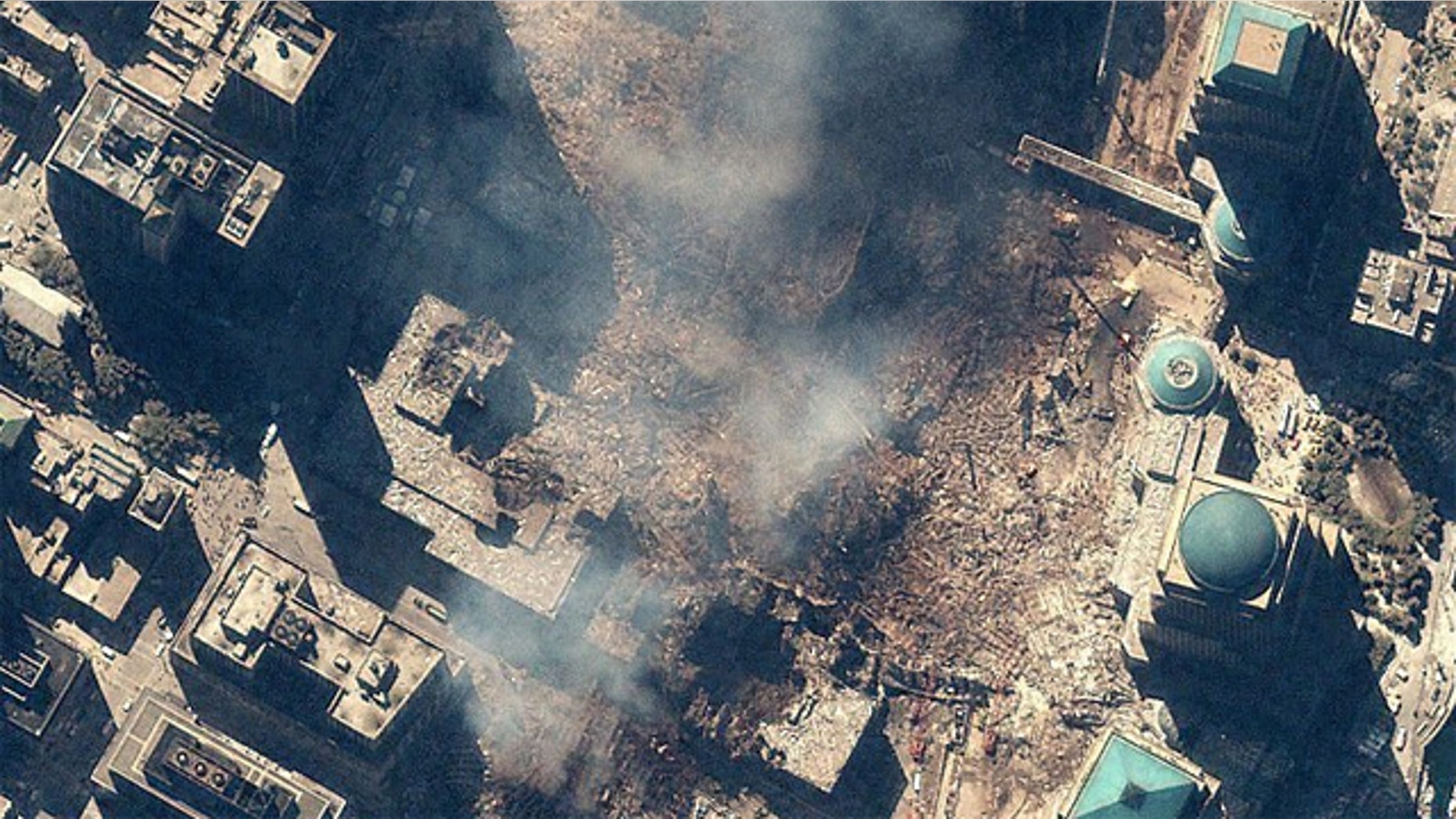 Space Imaging's IKONOS satellite collected this image of Manhattan, New York at 11:54 a.m. EDT on Sept. 15, 200. The image shows the remains of the 1,350-foot towers of the World Trade Center, and the debris and dust that settled throughout the area. Also visible are many emergency and rescue vehicles in the streets. IKONOS orbits 423 miles above the Earth's surface at a speed of 17,500 miles per hour.