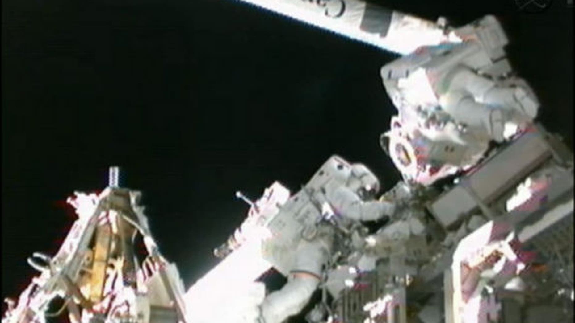 NASA astronaut Sunita Williams (left) helps Japanese astronaut Akihiko Hoshide (right) prepare the space station's robotic arm during their spacewalk on Sept. 5, 2012.