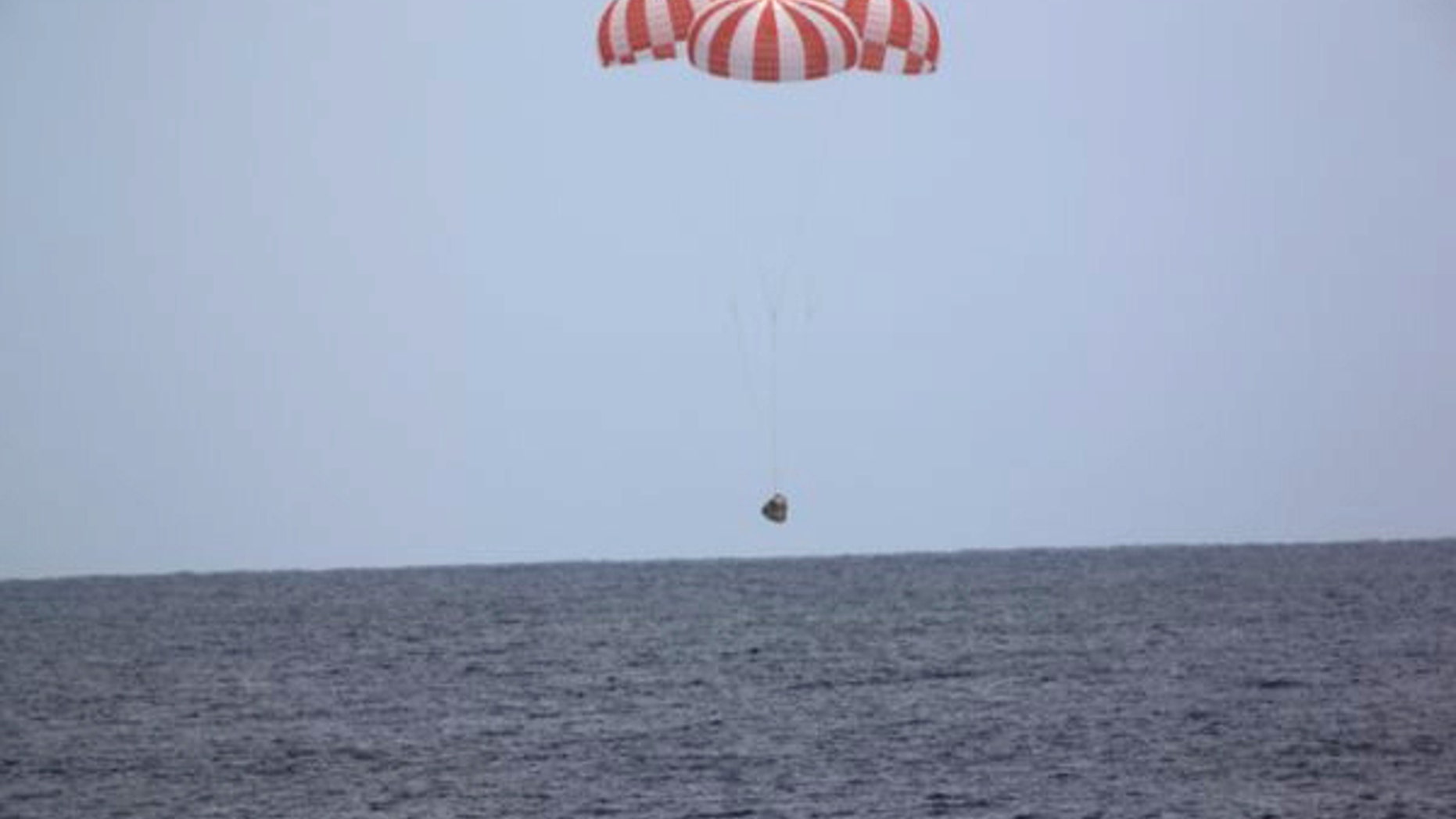 In this photo released by SpaceX, a SpaceX capsule containing science samples from NASA's one-year space station resident, approaches the Pacific Ocean, a few hundred miles off the Southern California coast, Wednesday, May 11, 2016. (SpaceX via AP)
