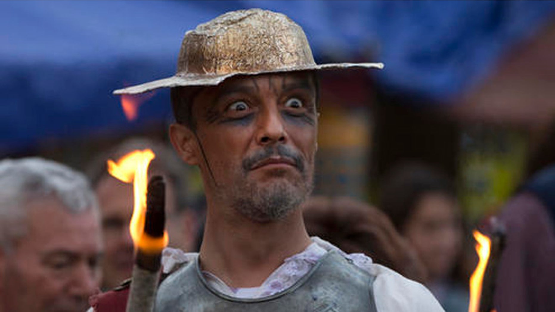 A man dressed as the character of Don Quixote holds a flaming stick during a mock funeral for Spanish writer Miguel de Cervantes, author of 'Don Quixote' to commemorate the 400th anniversary of his death, in his birthplace of Alcala de Henares, Spain, Friday April 22, 2016. (AP Photo/Paul White)
