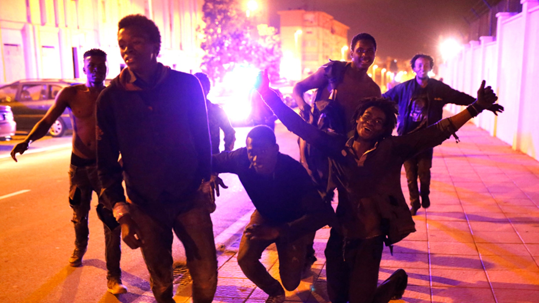 Migrants react after storming a fence to enter the Spanish enclave of Ceuta, Spain, Friday, Feb. 17, 2017.
