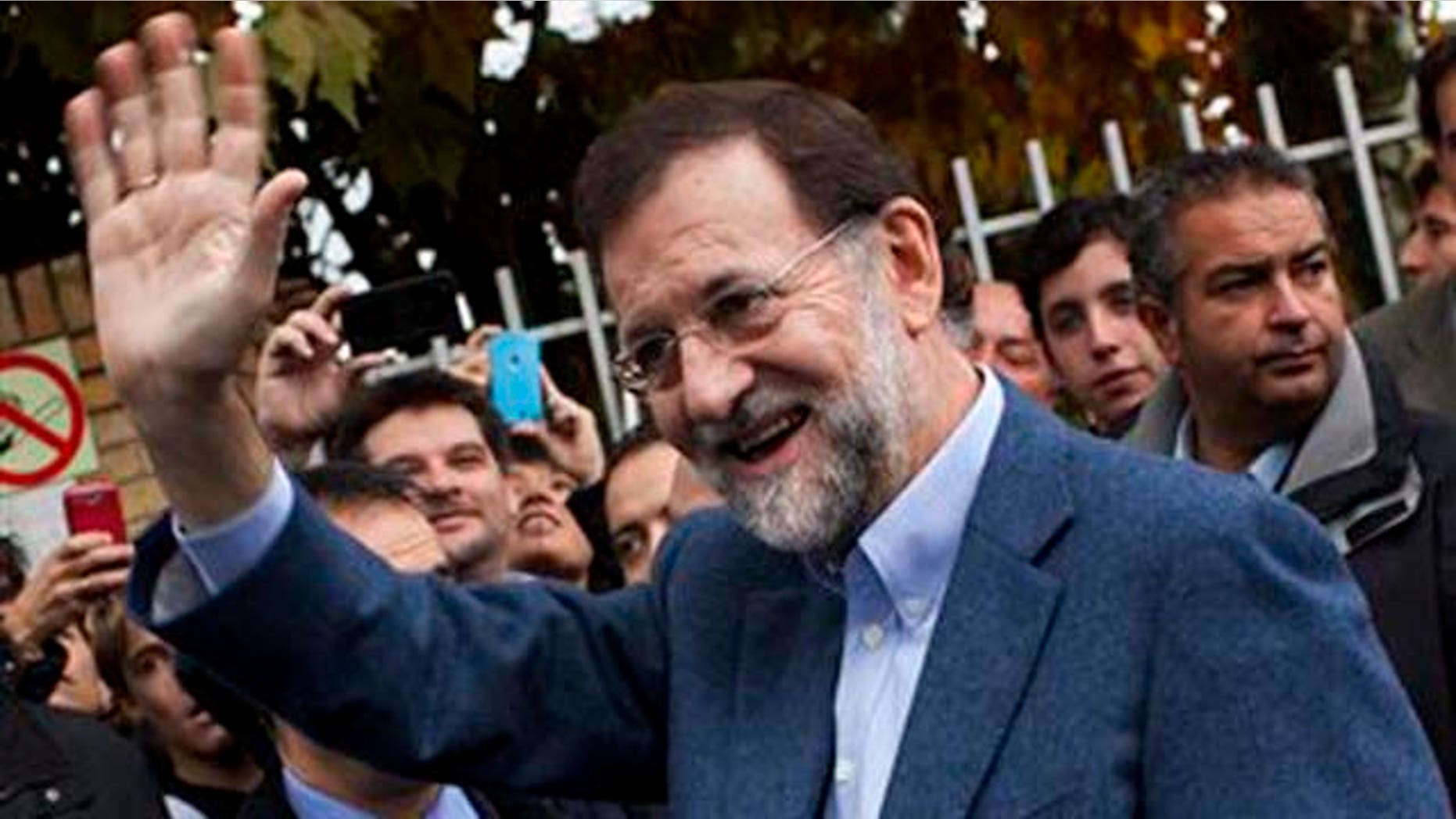 Conservative Popular Party candidate Mariano Rajoy waves after voting at a voting station in Madrid, Sunday Nov, 20, 2011.