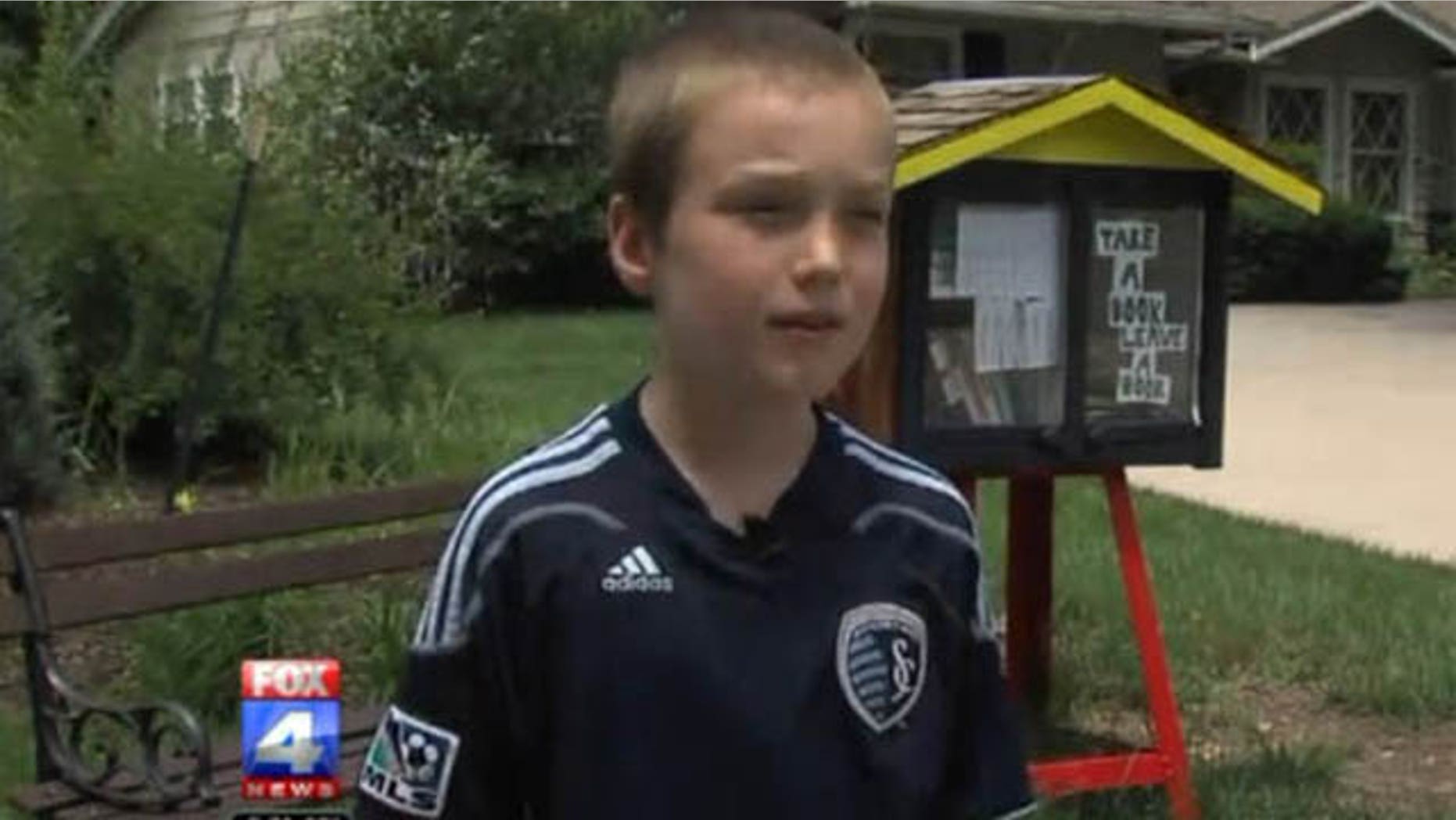 This photo shows 9-year-old Kansas City boy Spencer Collins with his outdoor library (Courtesy WDAF-TV)