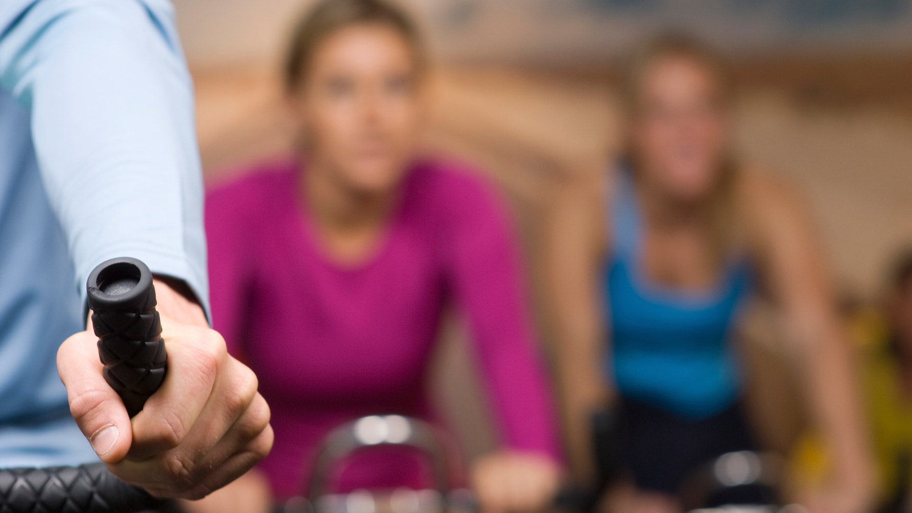 Women Working Out on Exercise Bicycles at Gym
