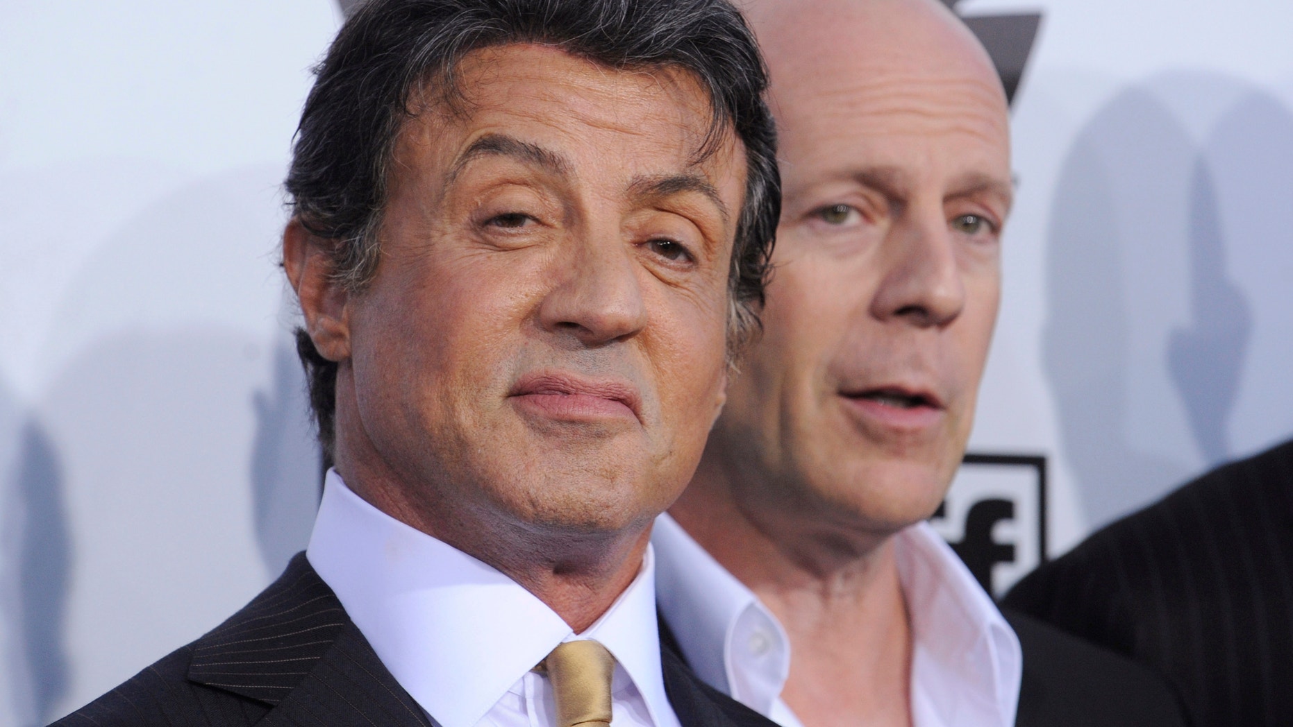 Cast members Sylvester Stallone (L) and Bruce Willis attend the premiere of the film "The Expendables" in Los Angeles August 3, 2010.