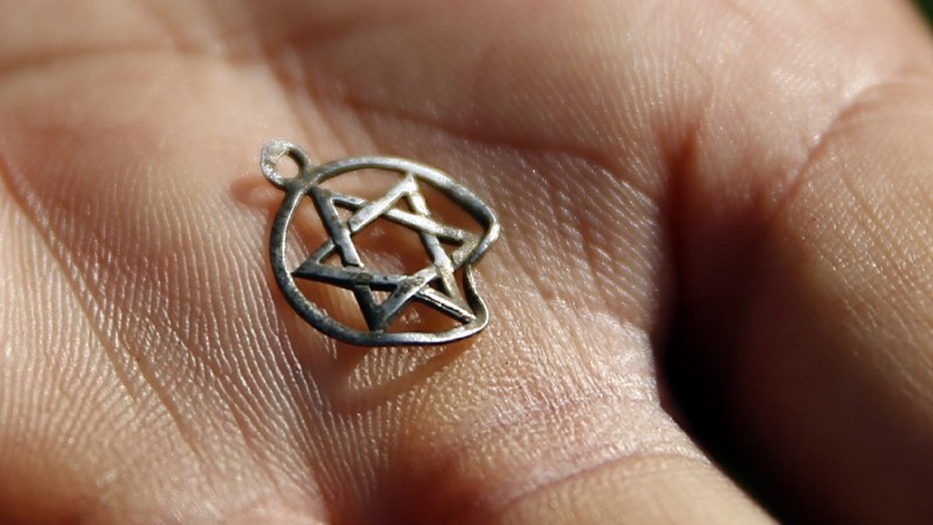FILE -- A medallion in the shape of the Star of David is shown after being discovered in the perimeter of a Nazi death camp in Sobibor September 18, 2014.