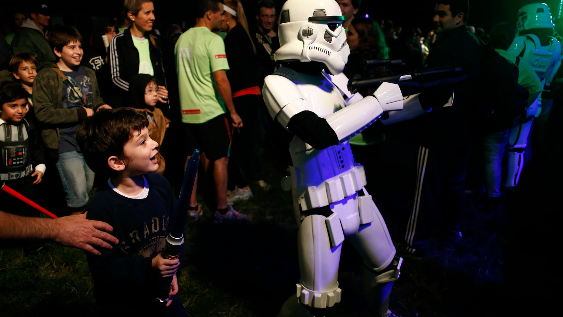 May 3, 2014. A boy looks at a man dressed as a stormtrooper from the Star Wars movies before the Star Wars Run race ahead of Star Wars Day in Buenos Aires.
