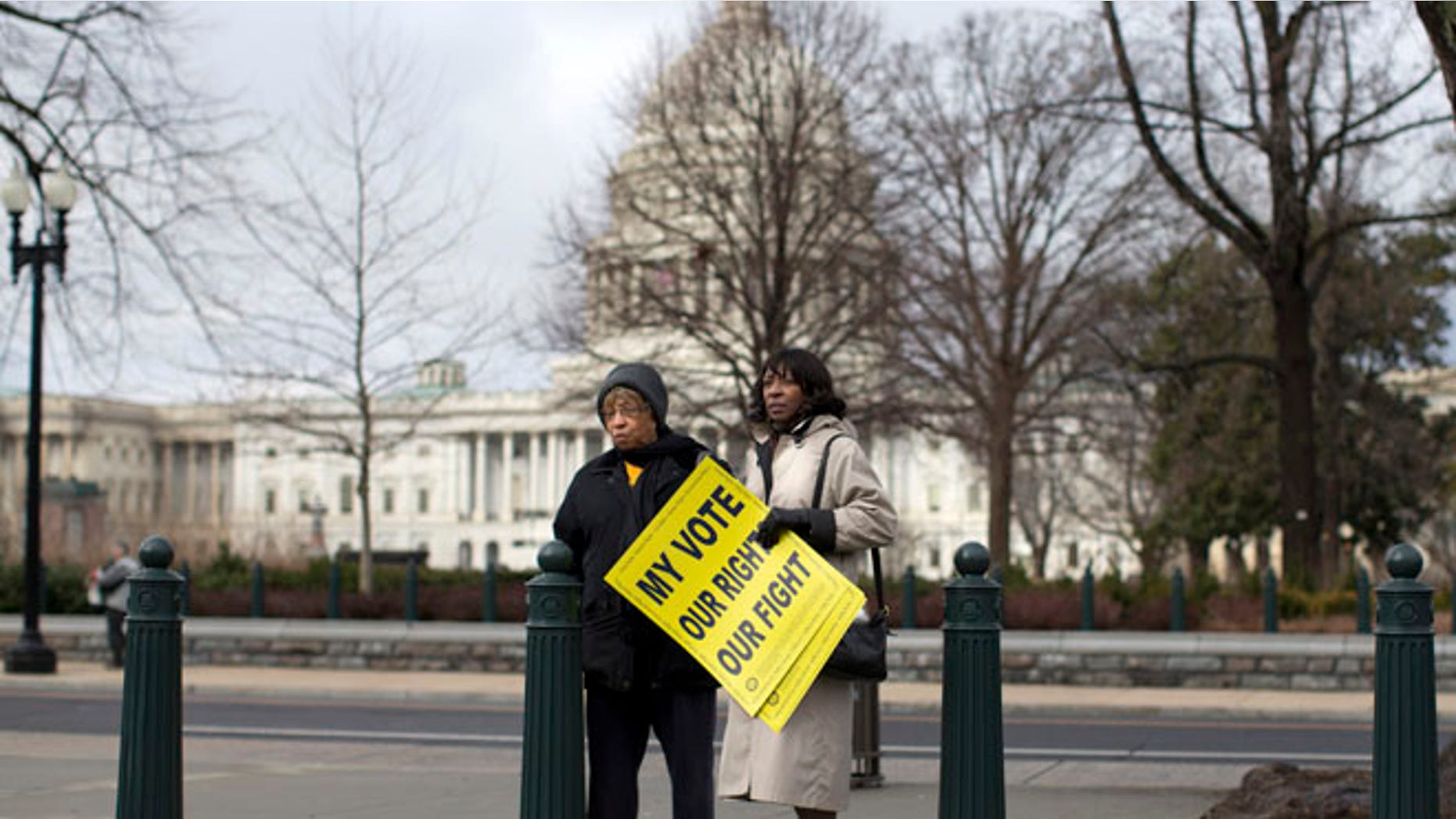 FILE: Feb. 27, 2013: People standing outside the Supreme Court in Washington before the start of a rally during arguments in the Shelby County, Ala., v. Holder case.