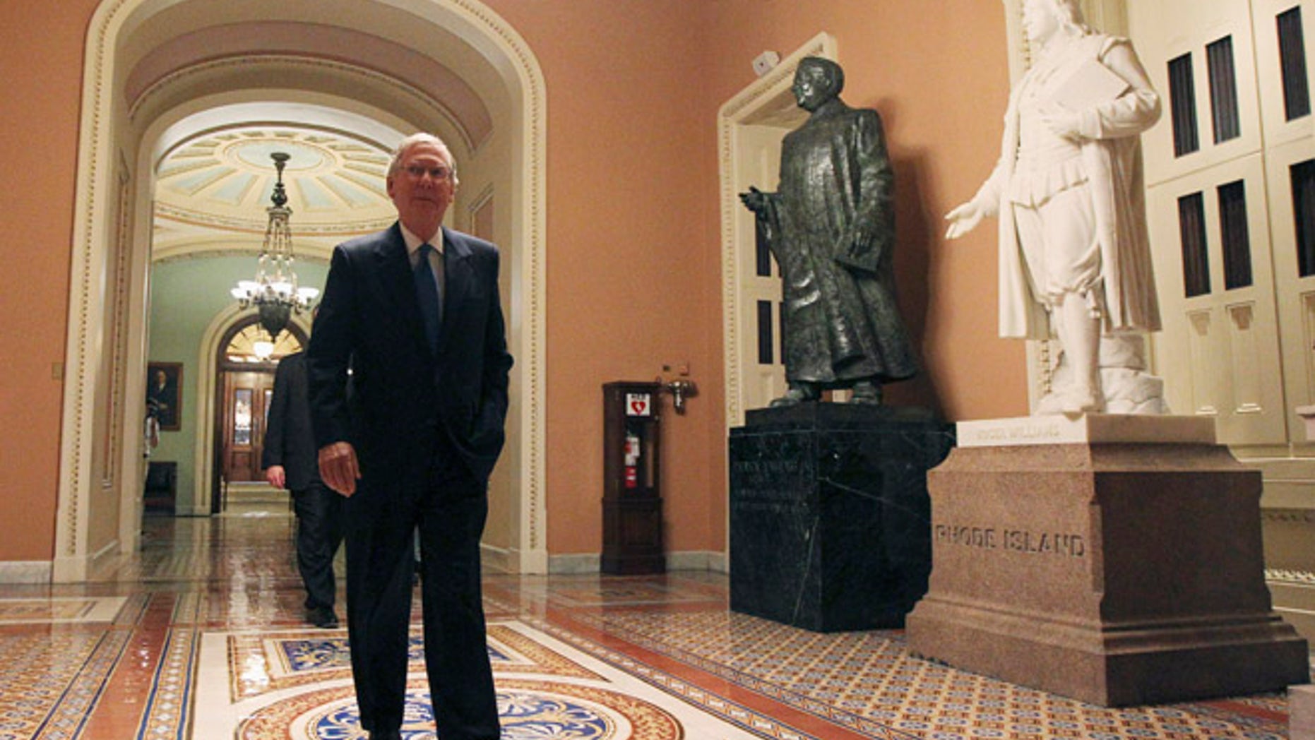Sept. 30, 2013: U.S. Senate Minority Leader Mitch McConnell (R-KY) walks past statues of former U.S. Senators Patrick Anthony McCarran (2nd R) and Roger Williams (R) as he departs the Senate chamber.