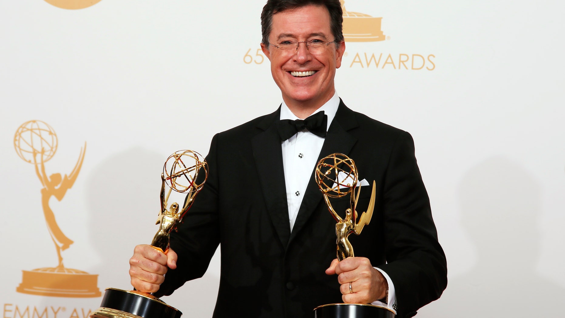 Stephen Colbert from Comedy Centrals Variety Show "The Colbert Report" poses backstage with his awards for Outstanding Variety Series and Outstanding Writing For A Variety Series at the 65th Primetime Emmy Awards in Los Angeles September 22, 2013. REUTERS/Lucy Nicholson (UNITED STATES Tags: ENTERTAINMENT) (EMMYS-BACKSTAGE) - RTX13W1W