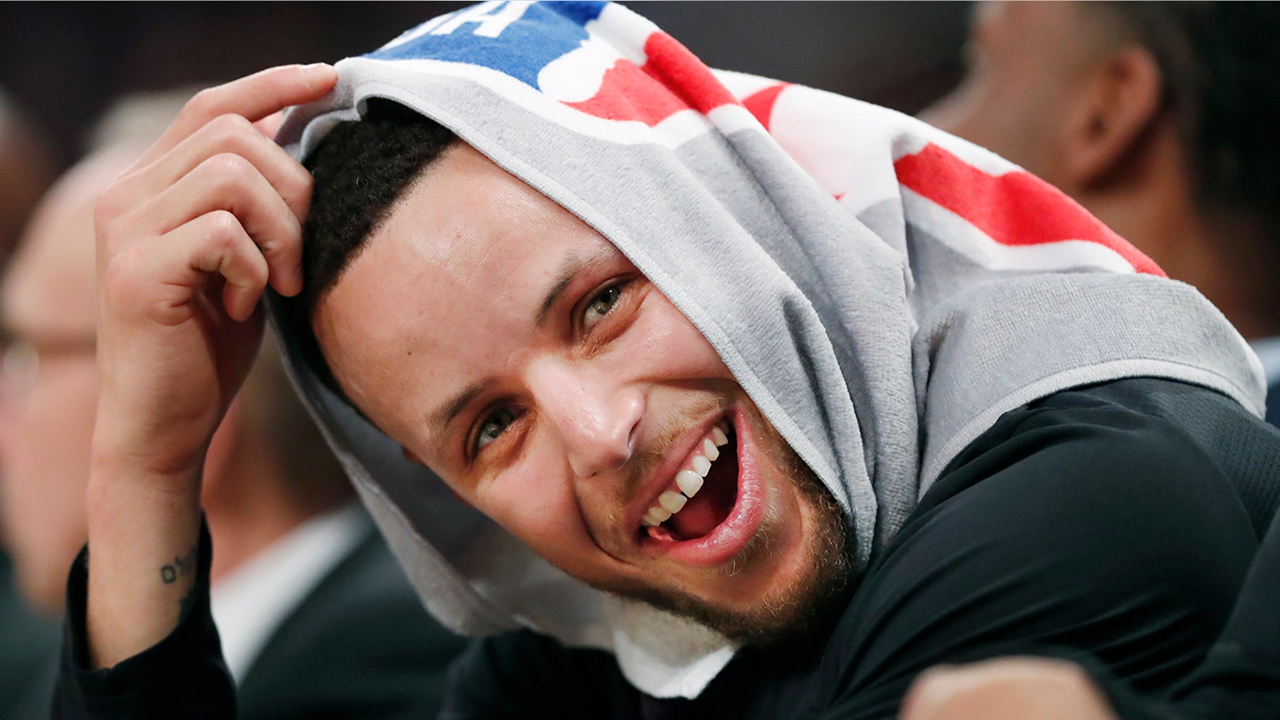 Golden State Warriors guard Stephen Curry, his head covered by a towel, laughs with teammates during the second half of an NBA basketball game against the New York Knicks, Monday, Feb. 26, 2018, in New York.