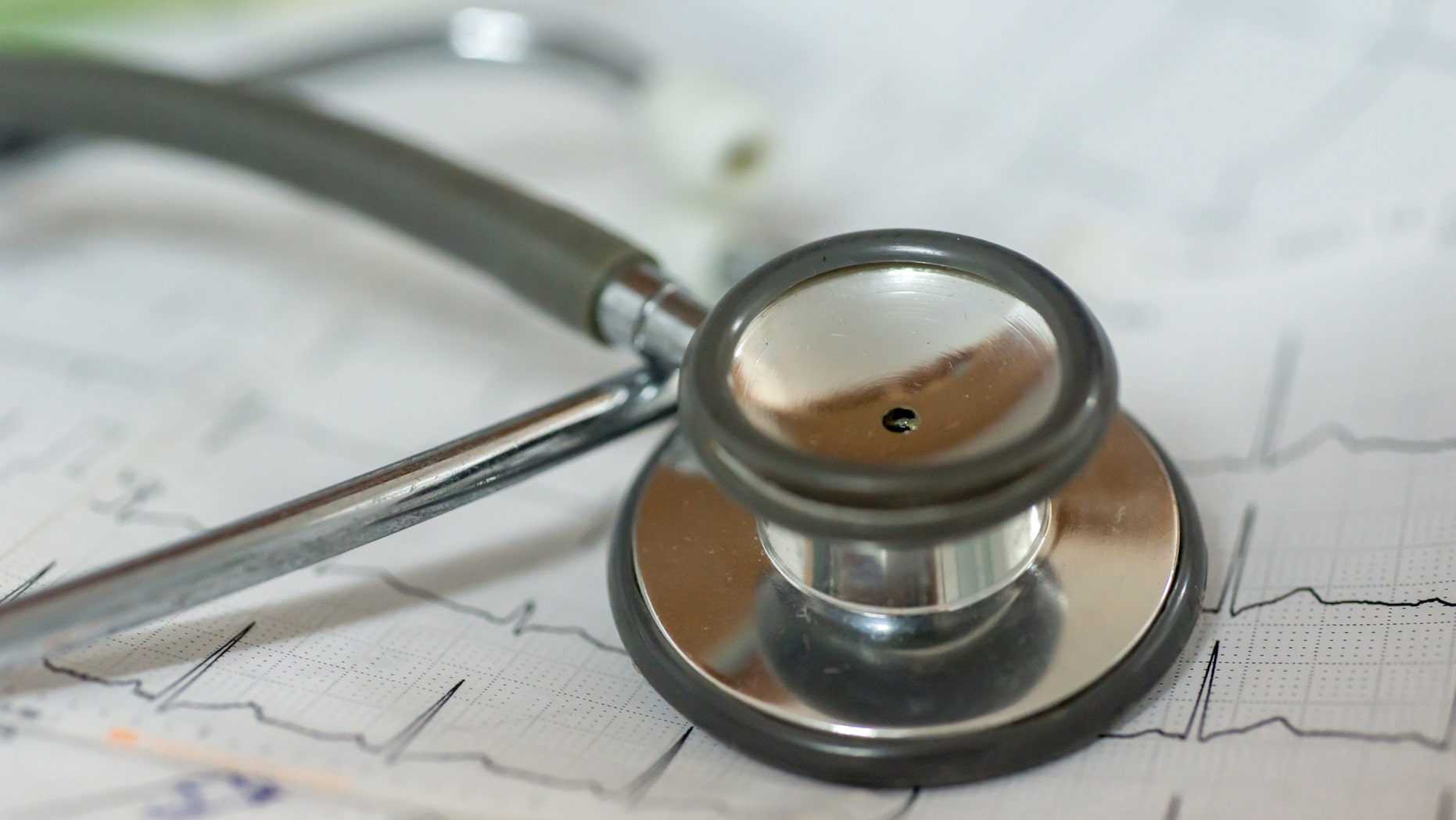 A stethoscope on a pile of 12-lead ECG readings.