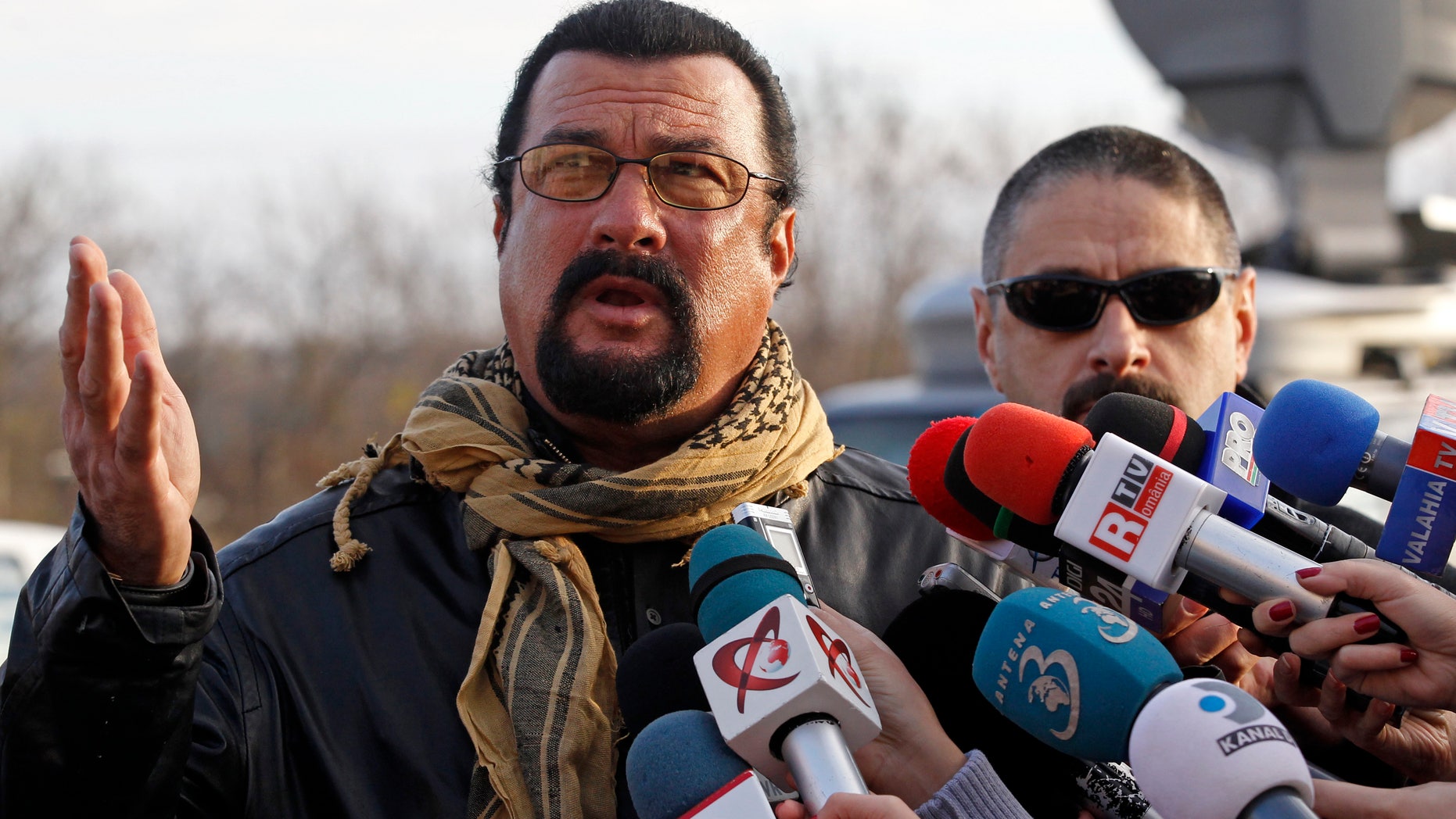 U.S. actor Steven Seagal talks to the media after he adopted Grivei, a stray dog from the Dogtown kennel in Uzunu, 40 km (24 miles) south of Bucharest November 17, 2013.