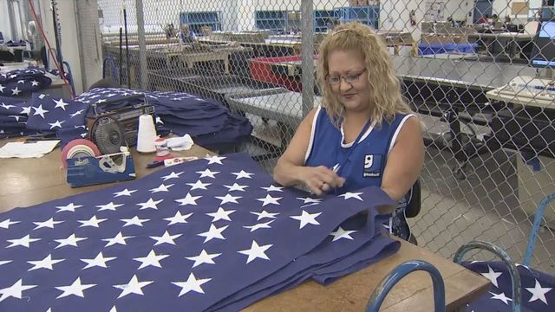 Goodwill employee works on flag at Goodwill Flag Center in South Florida. (WSVN)