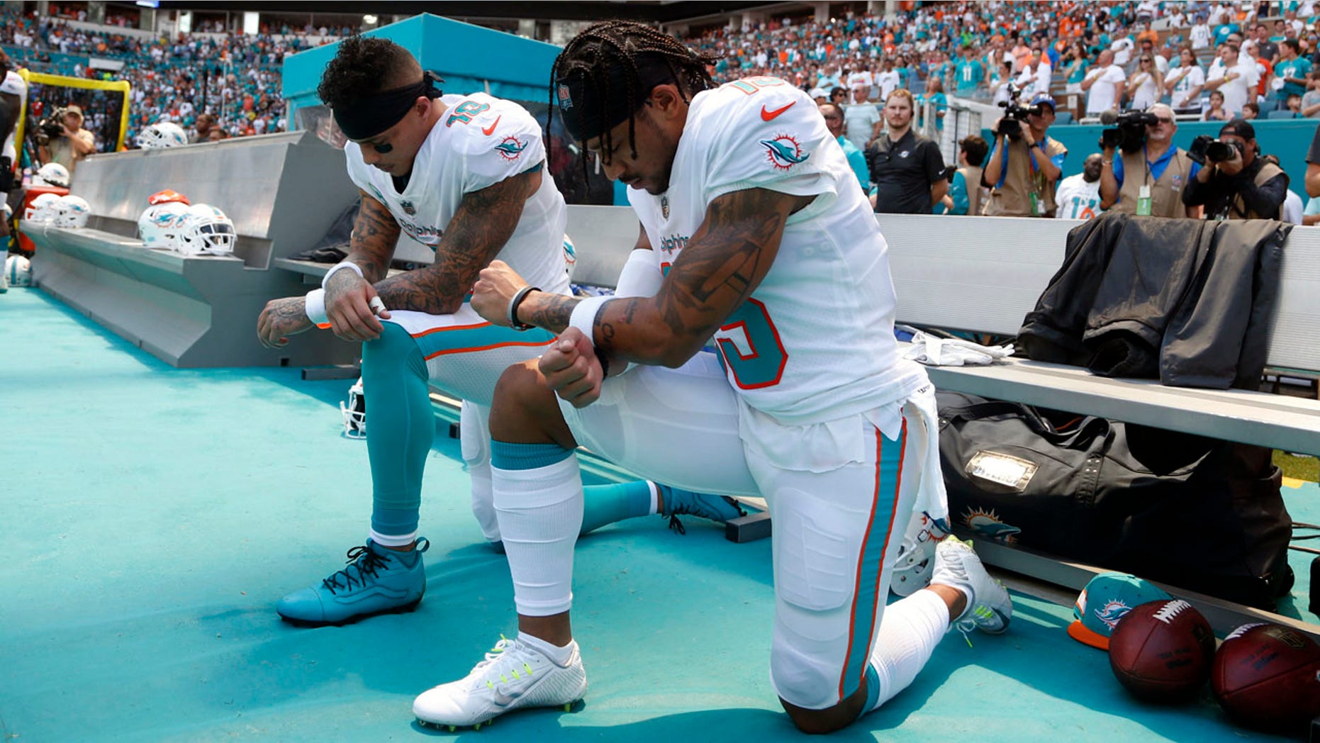 Miami Dolphins receivers Kenny Stills, left, and Albert Wilson kneel during the playing of the national anthem prior to their game against the Tennessee Titans Sunday.