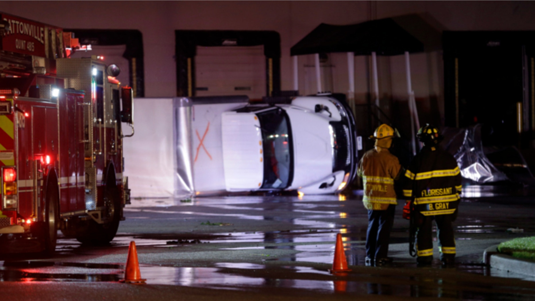 May 31, 2013: Rescue personnel stand near overturned trucks in an industrial park after strong storms moved through the area in St. Louis.